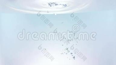 新鲜的气泡溅落到水里，在白色背景上缓慢地喷射，纯净干净